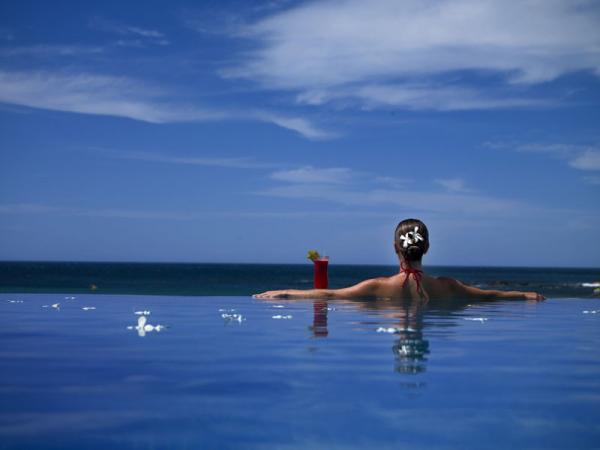 Femme libérienne en sirotant un cocktail dans une piscine à débordement